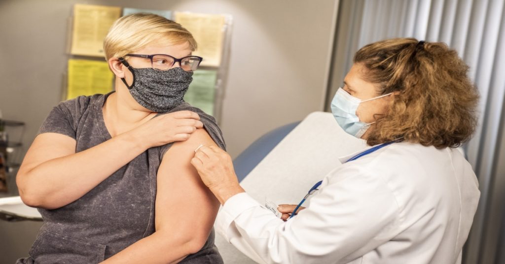 Woman getting a travel vaccine at a travel clinic.